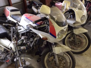 倉庫に保管された2台のヤマハFZR250。前面に埃が積もり、長期間放置された状態がわかる。