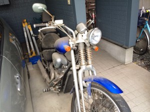 屋根付きのガレージに置かれた青いフロントフェンダーのホンダ・スティード400VLS。全体的に埃を被っており、長期間放置されていた様子がうかがえる。