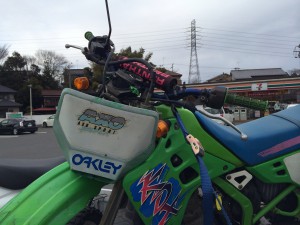 鮮やかなグリーンのKDX125SRを正面から撮影した写真。事故車の状態ながら、フロント部分が特徴的に映し出されています。