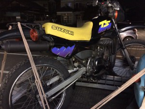 黄色シートが特徴的なスズキ TS50(SA11A)。不動車ながら屋内保管されていたため外装の状態は比較的良好。