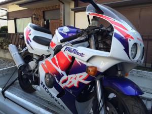 ホンダCBR400RRファイアーブレード(赤白青のトリコロールカラー)がトラック荷台に積載されている出張買取時の写真。カウルには「CBR」「FireBlade」のロゴが目立つ。
