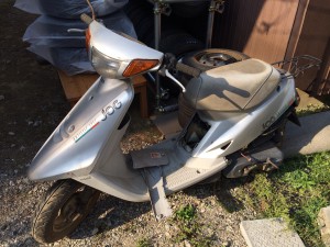 雨ざらし・劣化が進んだ廃車済みの原付スクーター ジョグの車体写真