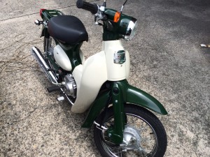 ホンダ リトルカブのフロント部分。レッグシールドやヘッドライトがレトロでおしゃれな雰囲気を演出。