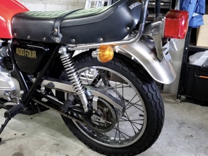 ホンダCB400FOURの後輪とサスペンション部分をクローズアップした画像。輝くリムと手入れの行き届いたメカニズムが見える。