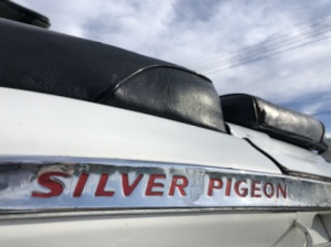 ホワイトボディのバイクに取り付けられた「SILVER PIGEON」と赤文字で書かれたエンブレムの近接写真。
