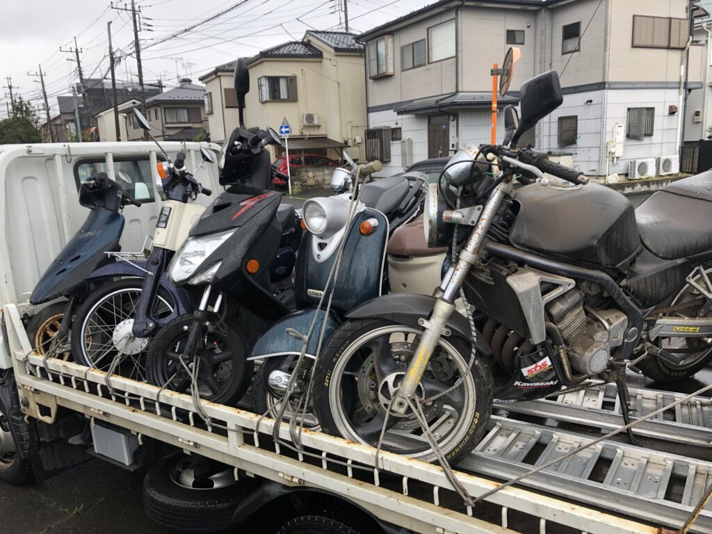 トラックに積まれた複数のバイクとスクーター。バイク処分の引き取り風景
