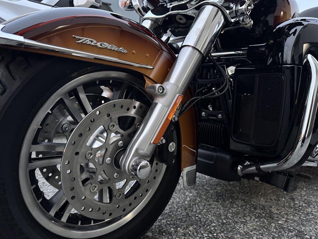ハーレーダビッドソン トライグライドウルトラ 2024年モデルのフロントホイール。デュアルディスクブレーキとトライクロゴが映えるクローズアップ写真。