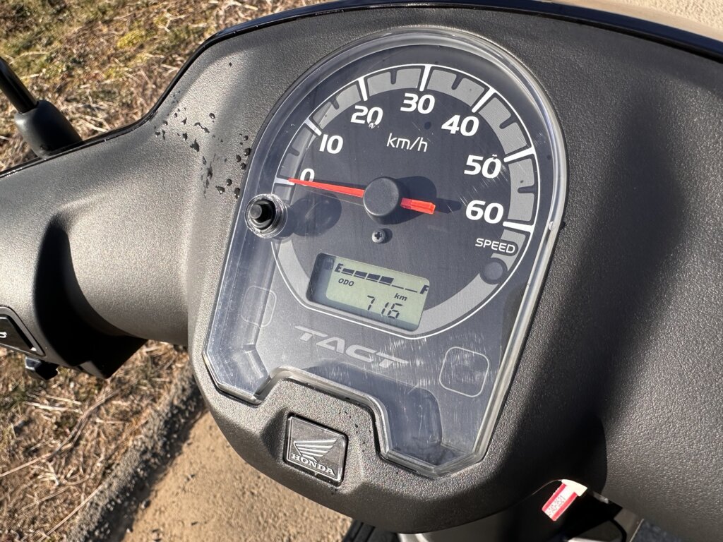 ホンダ タクトのスピードメーター。白い文字盤に走行距離716kmが表示されている様子。
