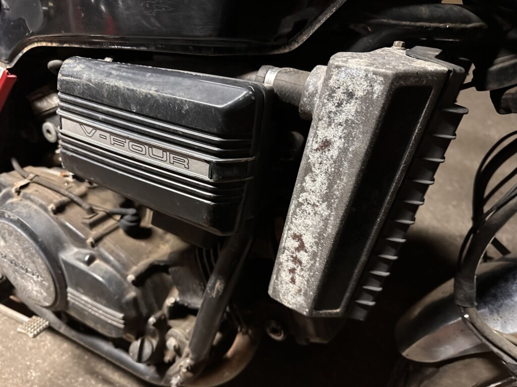 V-Fourと書かれたエンジン横のカバー部分。錆や汚れが見られる。