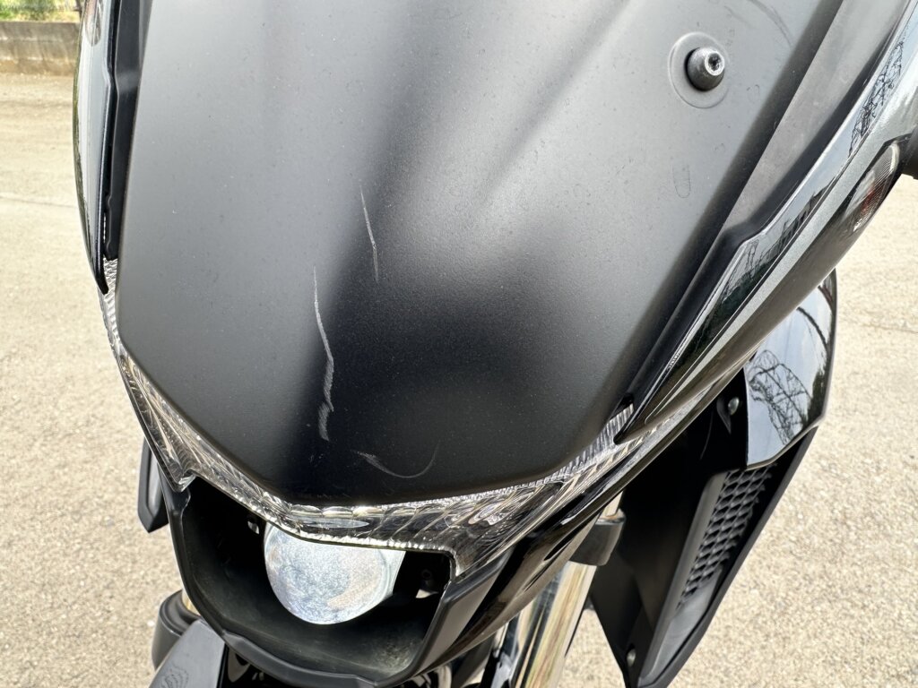 ヤマハ FZ25 のフロントカウルに入った擦り傷のクローズアップ。