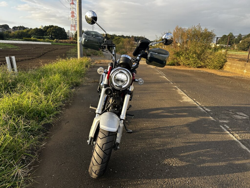 ホンダ ダックス125の正面。丸型ヘッドライト、左右のハンドガード、ハンドルに付いたスマートフォンホルダーが見える